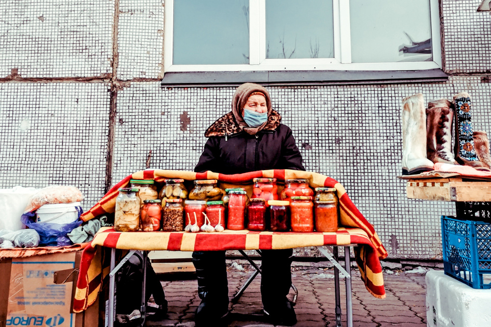 В ассортименте… Россия 2021 стрит фото улица люди фотограф наблюдения экзистенция город будни бабушка торговля продукты маска консервы прилавок ассортимент много зима холод