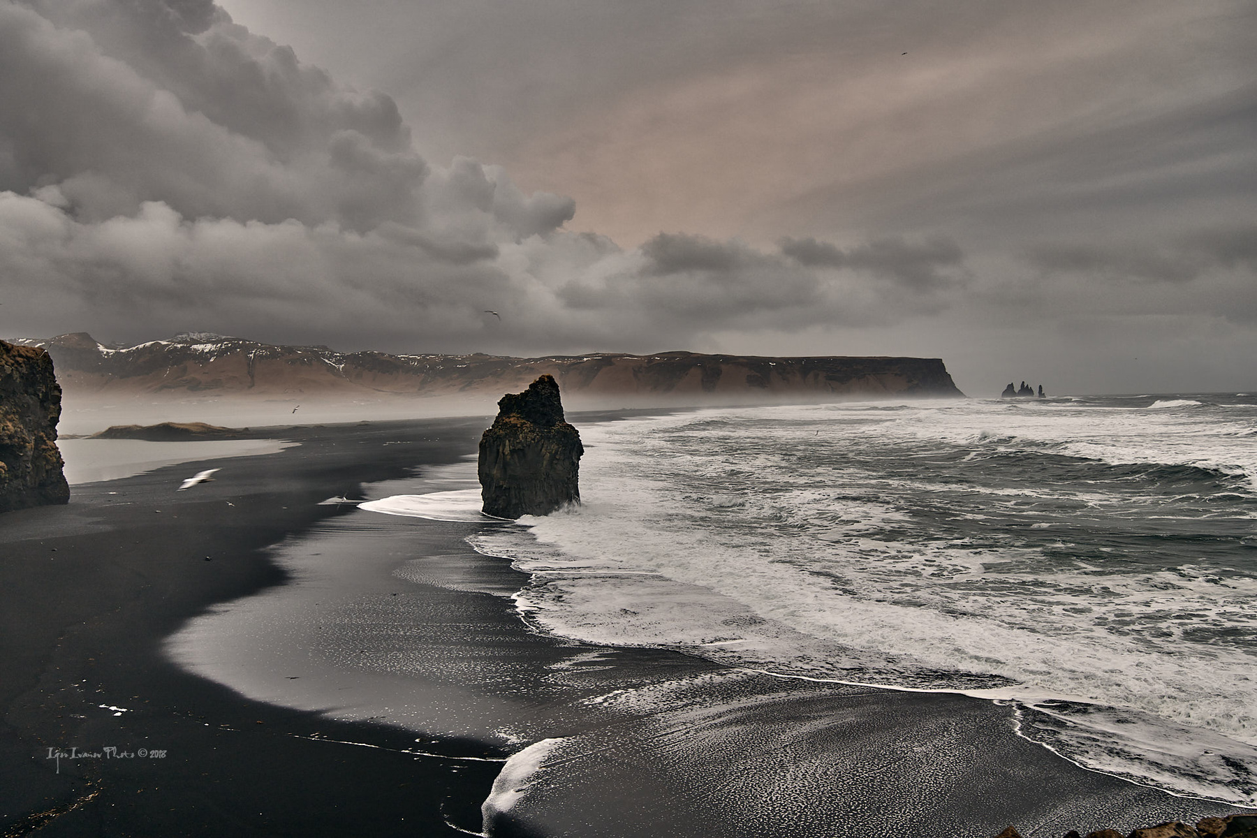 Исландия. Вид с мыса Didholaey на чёрный пляж и базальтовые столбы Reynisfjara 