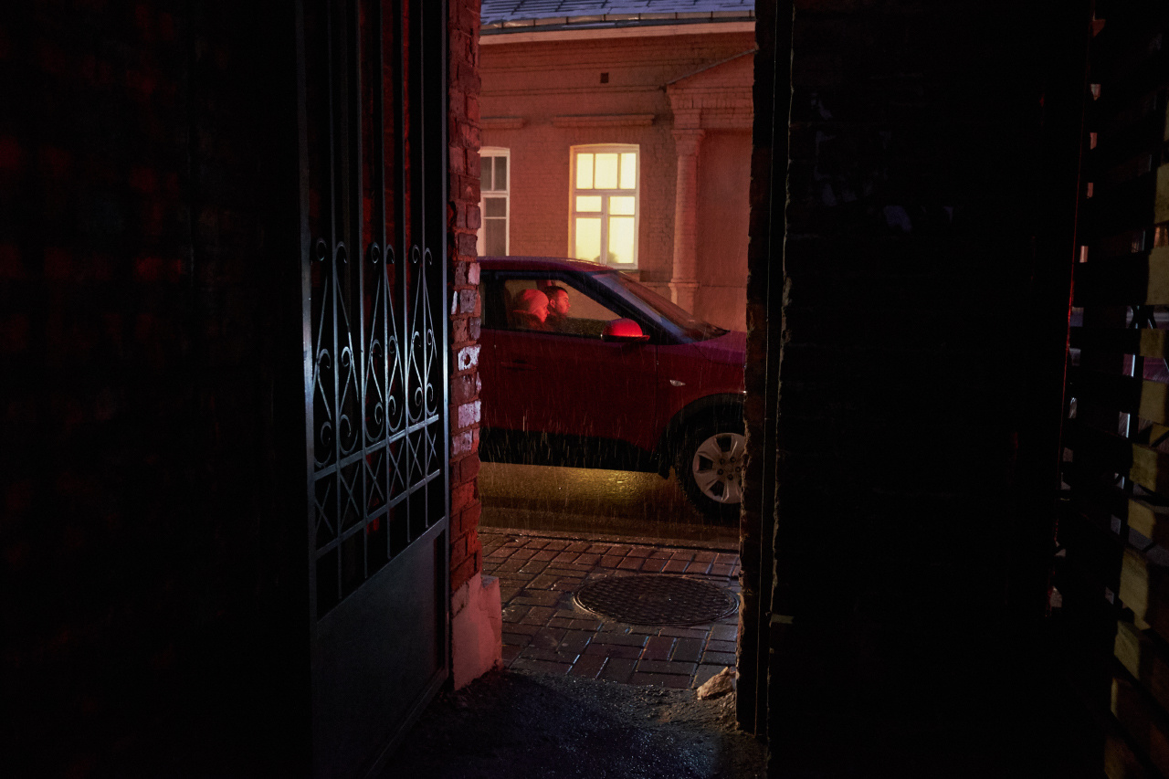 На светофоре вечер дождь двор калитка улица дом окна автомобиль люди