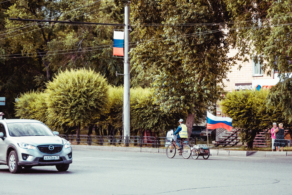 Из серии «Уличная экзистенция» Россия стрит фото улица люди фотограф наблюдения экзистенция город дорога путь флаг патриотизм праздник велосипед идеология
