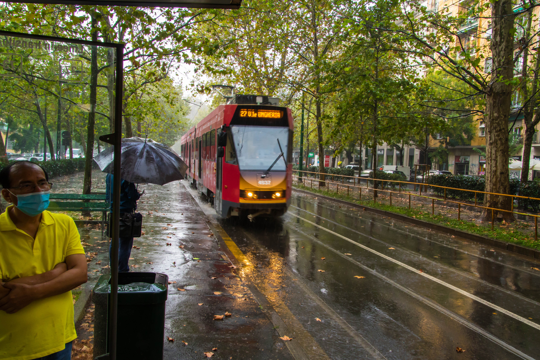 Дождь в Милане Город остановка трамвай дождь под зонтом