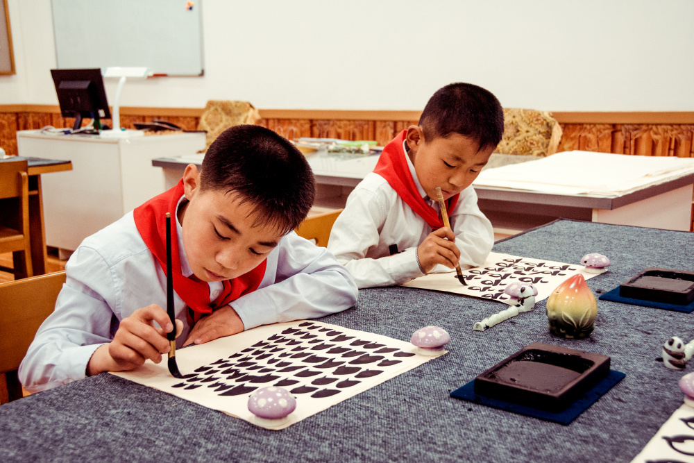Из серии «Чосон» Корея Северная КНДР репортаж документальная социализм идеология форма пионеры дети мальчик урок каллиграфия учеба образование