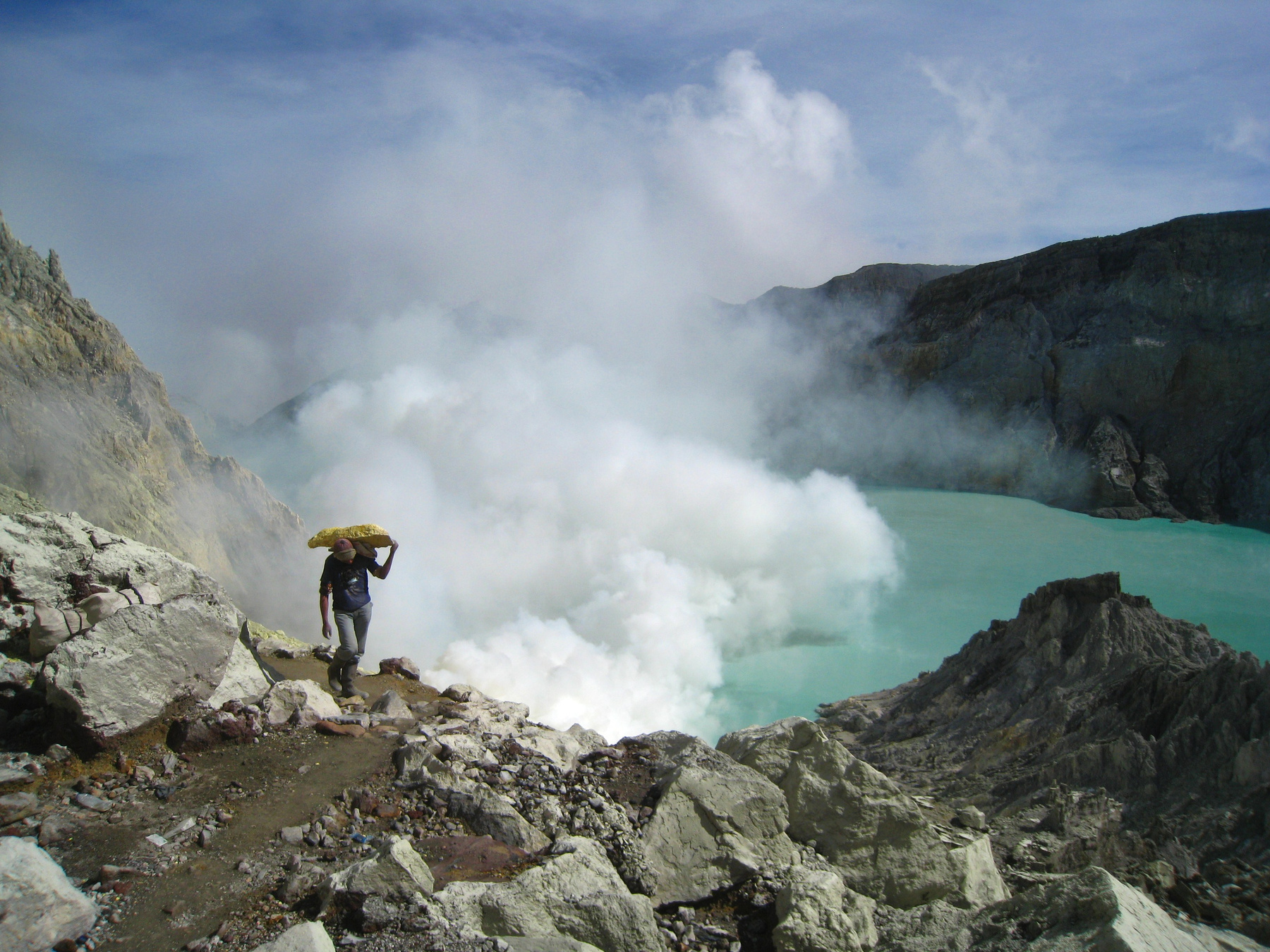 Человек с кусочком серы. Индонезия вулкан кратер горы скалы