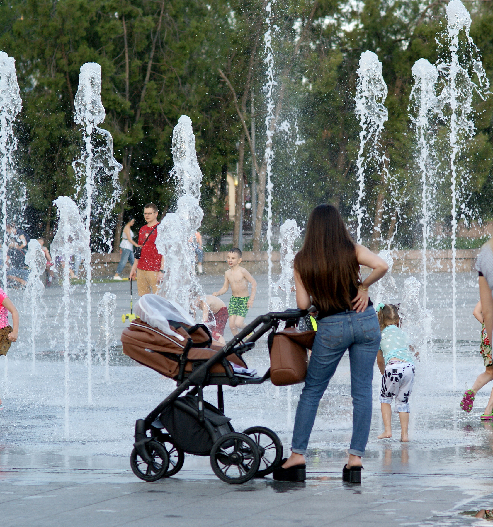 У фонтана Фонтан Серая площадь Николаев дети купание плескание забавы с водой молодая мама